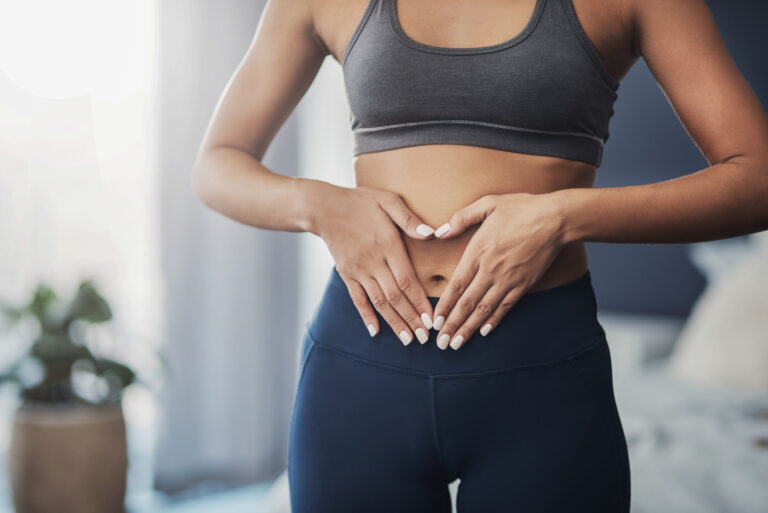 Frau mit ihren Händen über ihrem Bauch